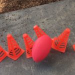 Sports cones being knocked down by a toy foootball