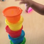 Child stacking colourful bowls at daycare