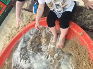 Children engage in sensory play with sand and water.